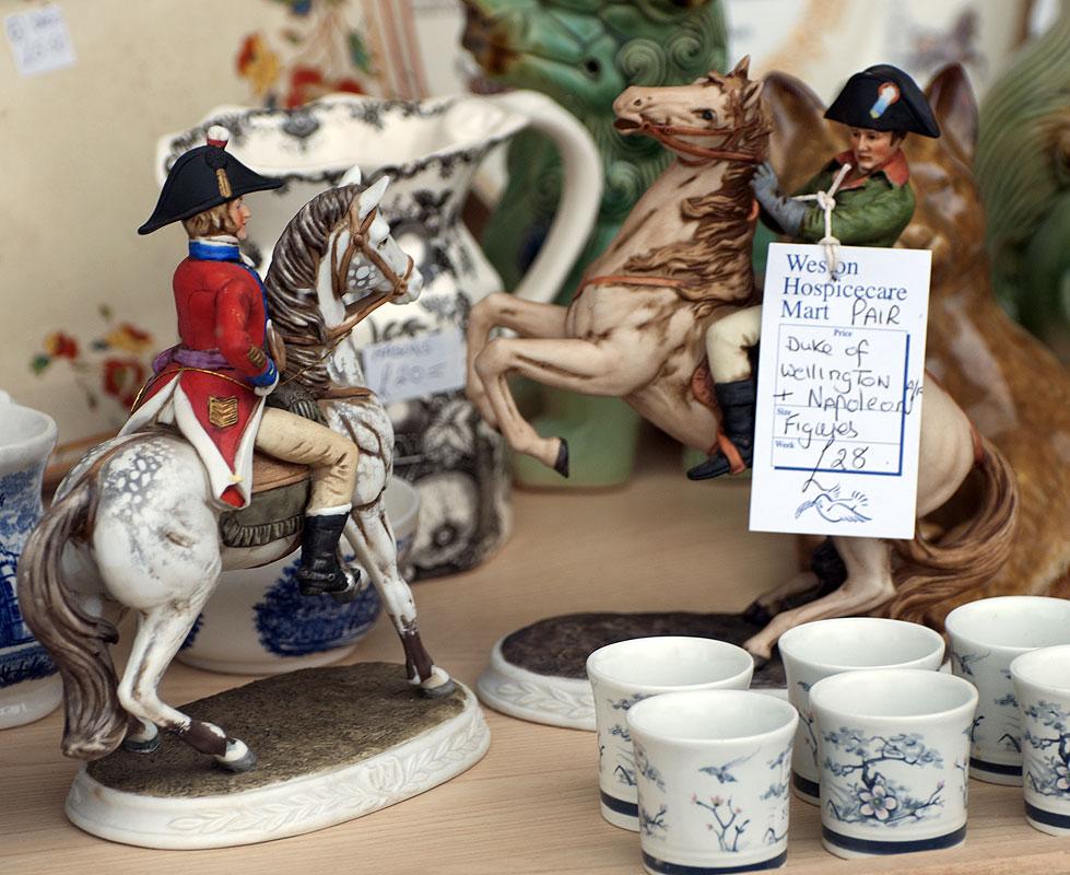Figures of Napoleon and Wellington face each other in a charity shop window display