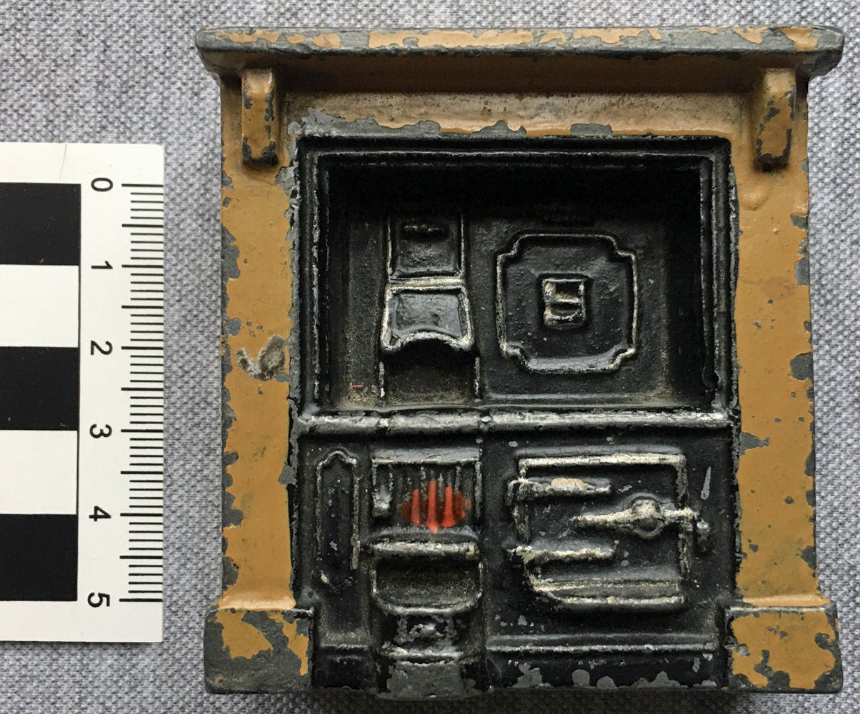 A miniature fireplace made from tin.